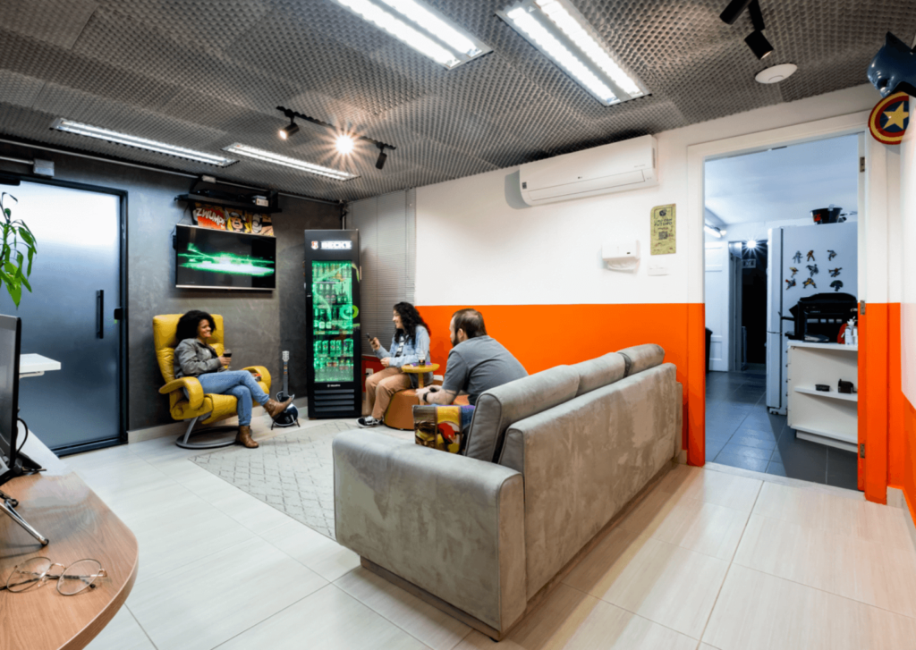 Imagem mostra pessoas sentadas na Blocktime Coworking conversando e rindo
