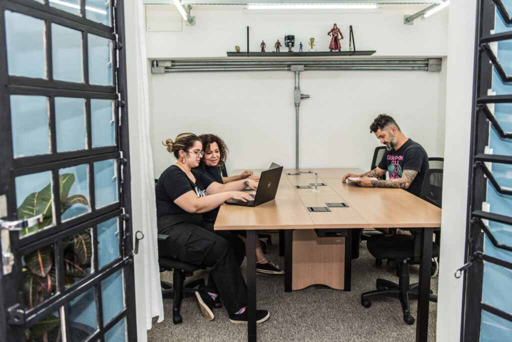 Imagem mostra espaço interno da Blocktime Coworking com pessoas trabalhando