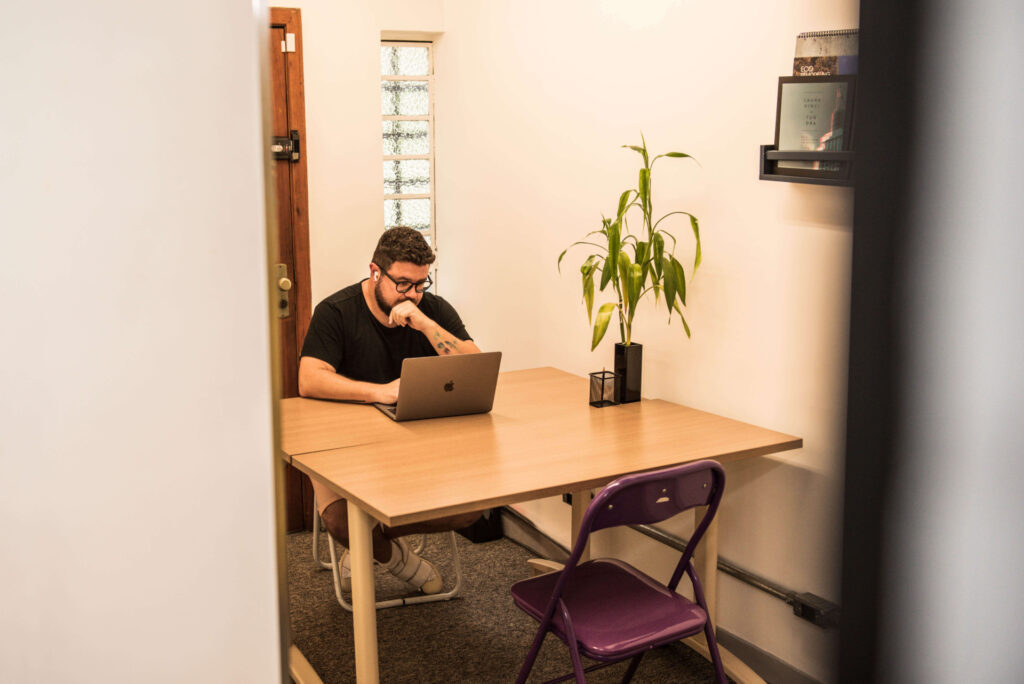 Imagem mostra homem jovem trabalhando em uma sala de reunião da Blocktime Coworking