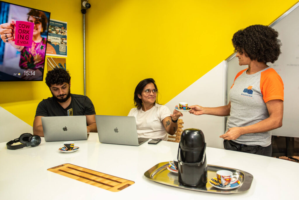Imagem mostra três pessoas trabalhando em um espaço da Blocktime Coworking
