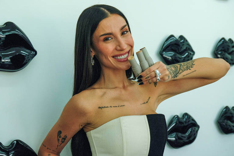 Imagem mostra Boca Rosa (Bianca Andrade), segurando seus produtos enquanto posa para foto