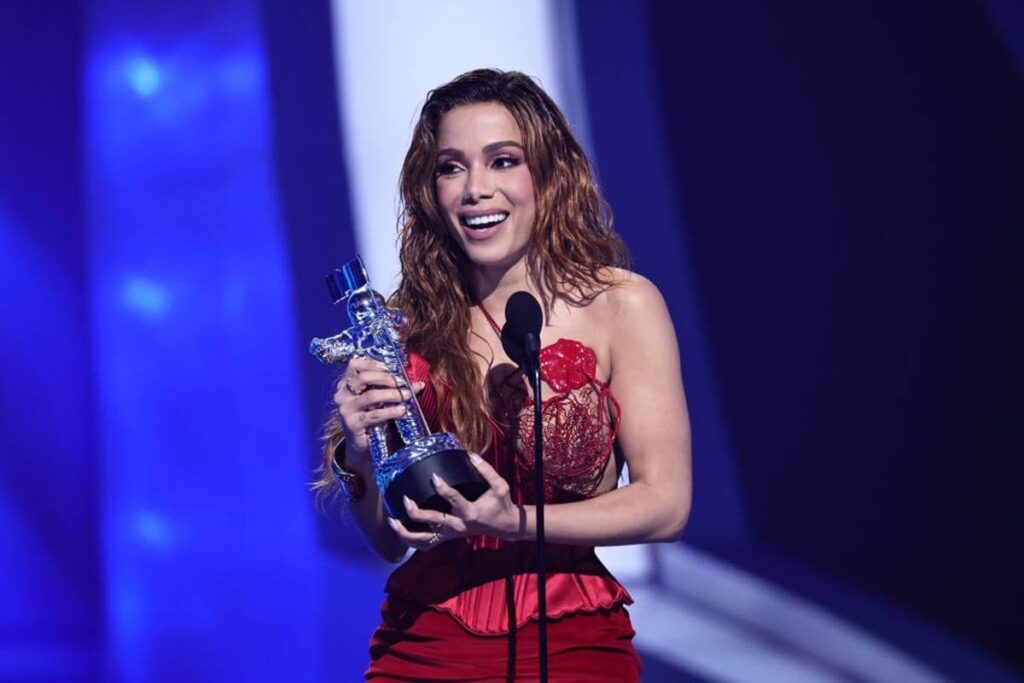 Imagem mostra a cantora Anitta segurando troféu