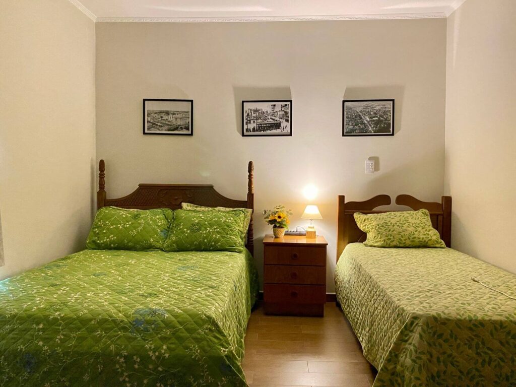 Imagem mostra o maior quarto da Blocktime Spaces, com uma cama de casal e uma cama de solteiro