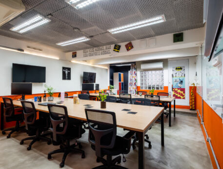 Imagem mostra um dos espaços da Blocktime Coworking: a Batcaverna, um ambiente decorado com heróis e utilizado para eventos, reuniões, palestras, etc