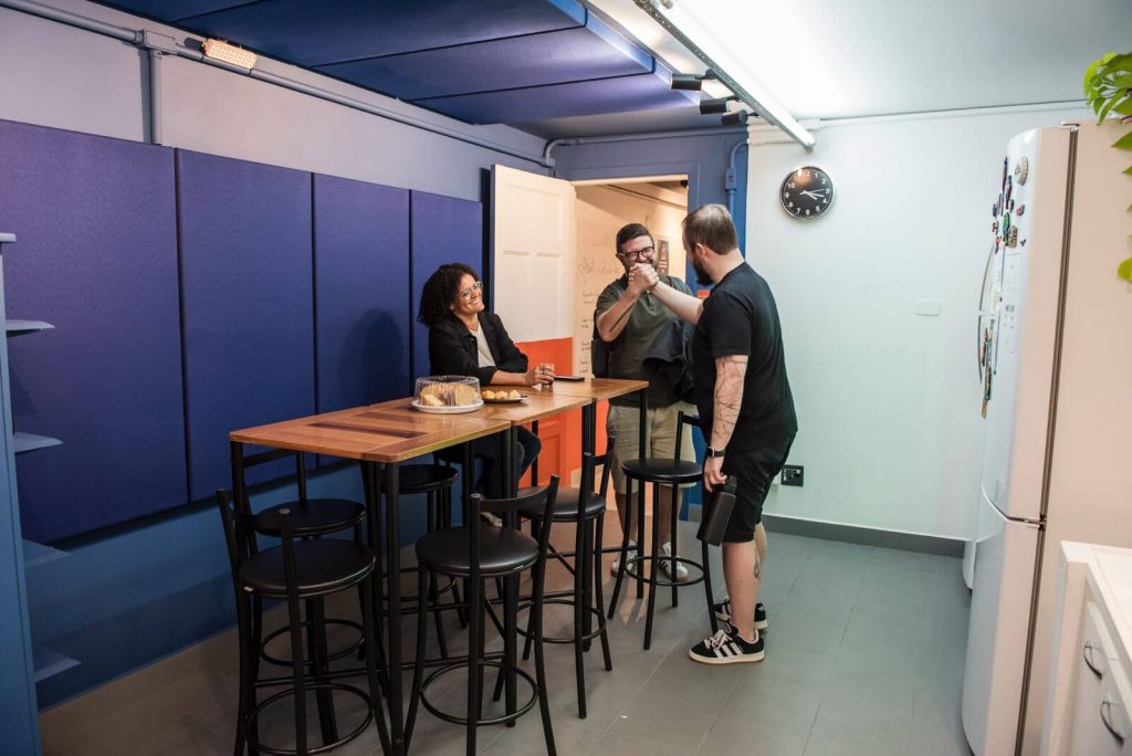 Imagem mostra pessoas na cozinha da Blocktime Coworking