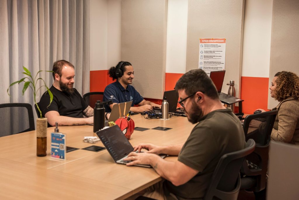 Imagem mostra pessoas trabalhando em espaço da Blocktime Coworking com estrutura e móveis ergonomicos