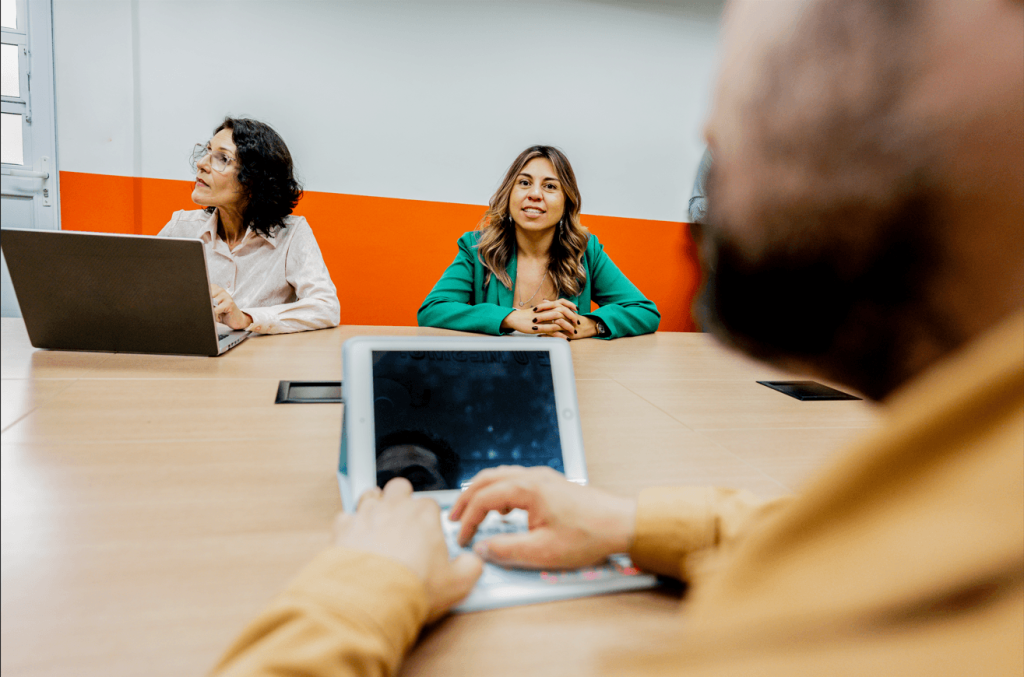 Equipe em sala de reunião analisando quanto custa um coworking