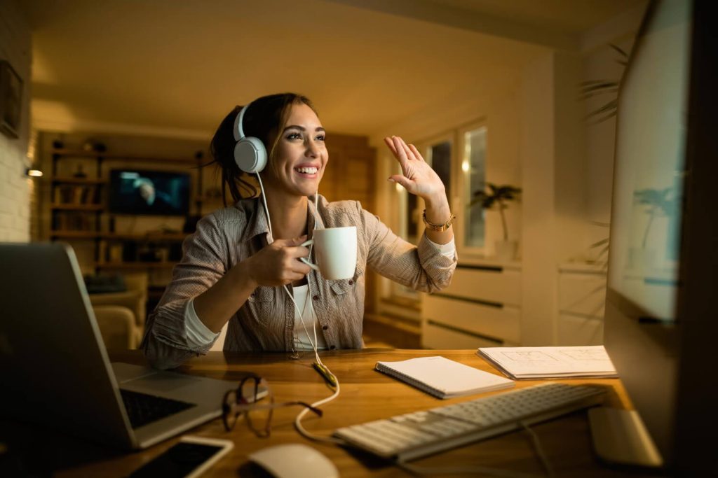 Profissional em home office participando de videochamada, uma das formas de colaboração adotadas no trabalho híbrido.