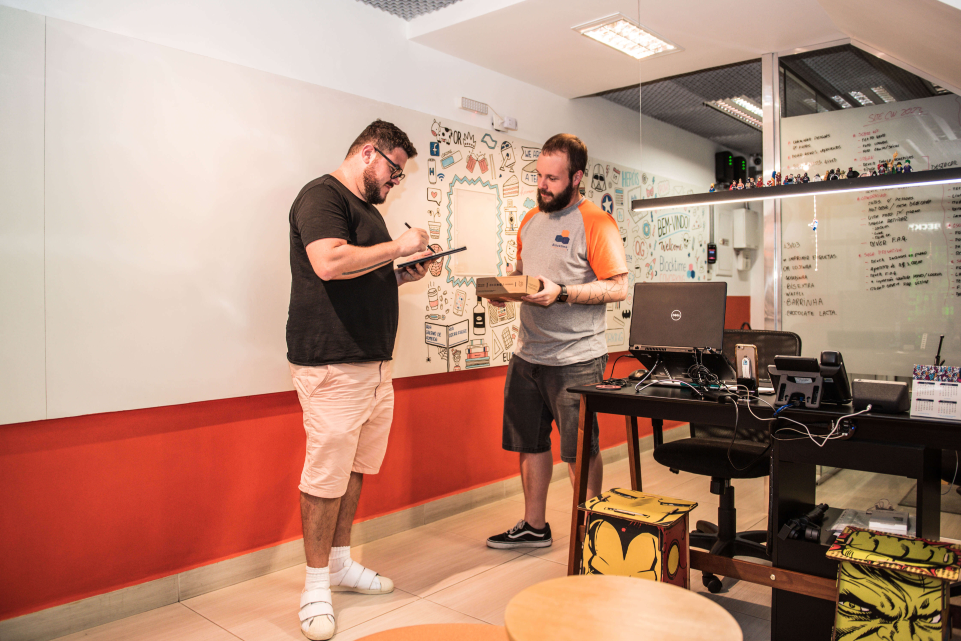 Imagem mostra um homem branco recebendo suas correspondências fiscais na recepção da Blocktime Coworking