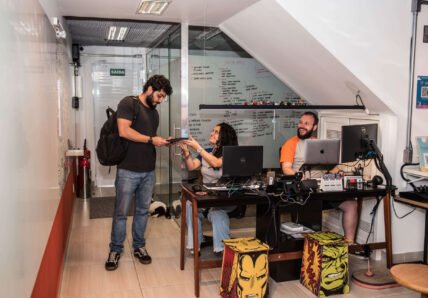 A imagem mostra a recepção da Blocktime Coworking, com uma mulher atendendo um cliente e o recebendo na unidade