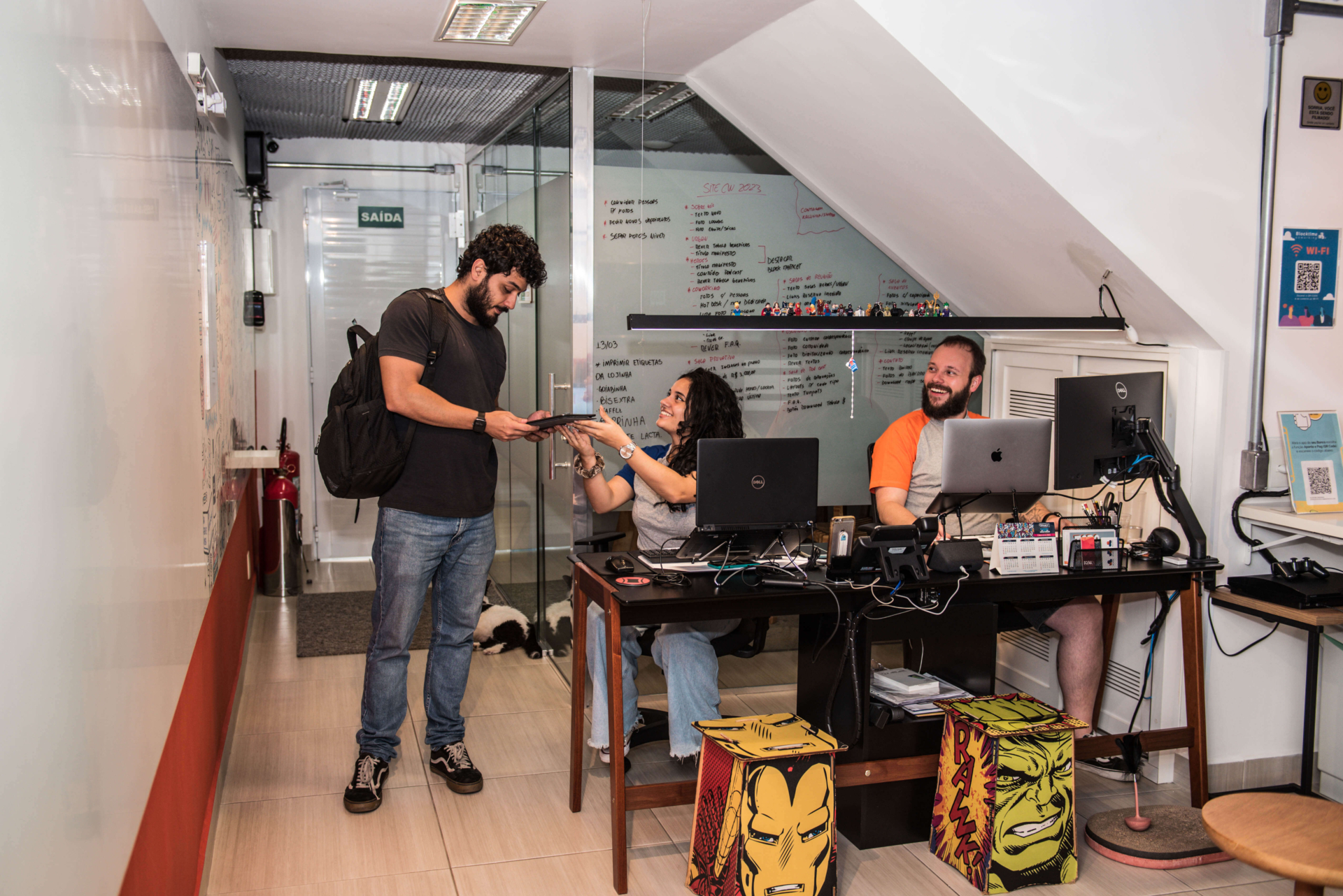 A imagem mostra a recepção da Blocktime Coworking, com uma mulher atendendo um cliente e o recebendo na unidade