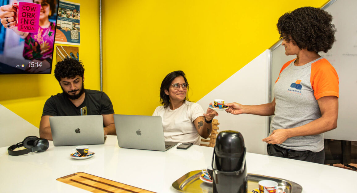 Imagem mostra três pessoas trabalhando em um espaço da Blocktime Coworking