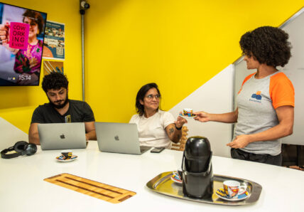 Imagem mostra três pessoas trabalhando em um espaço da Blocktime Coworking
