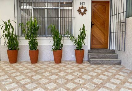 A imagem mostra a entrada da casa Blocktime Spaces, apresentando a fachada