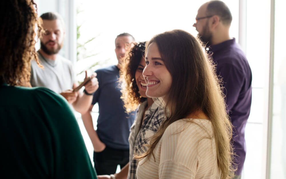 Imagem mostra grupo de pessoas diversas, homens e mulheres, conversando