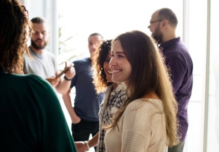 Imagem mostra grupo de pessoas diversas, homens e mulheres, conversando