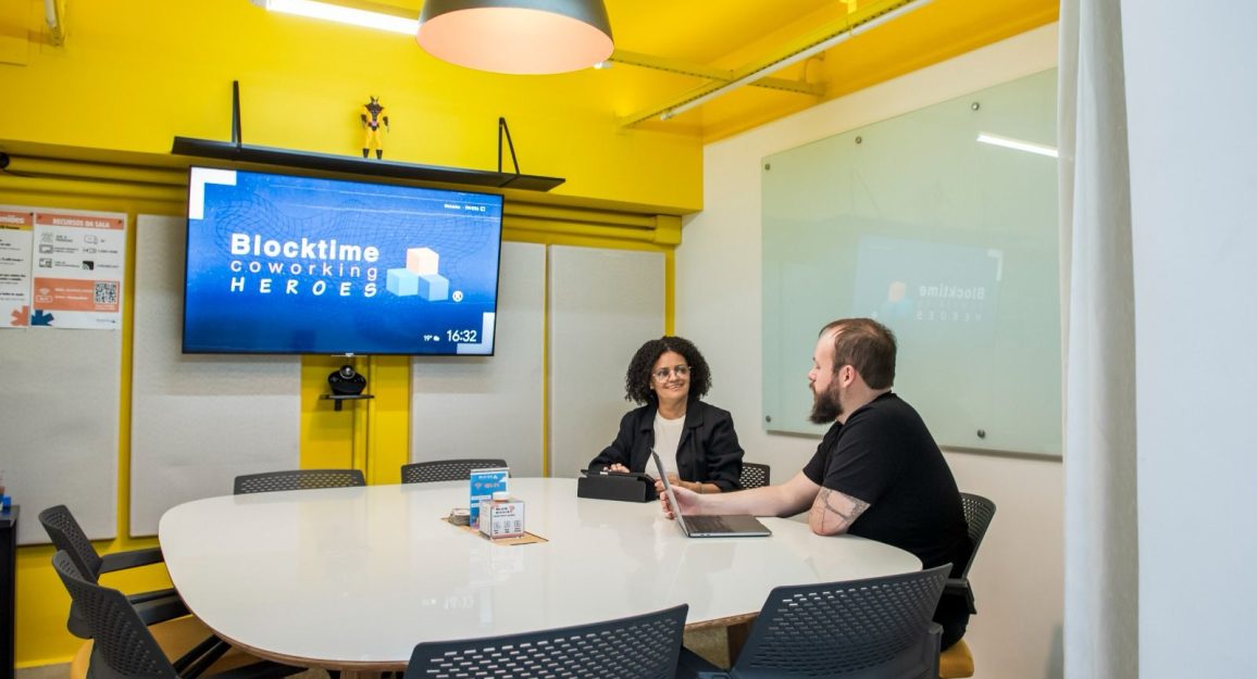 Imagem mostra espaço da blocktime coworking com móveis para uma reunião perfeita