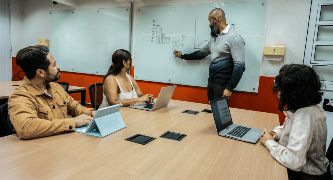 Equipe em sala de reunião em Pinheiros com apresentação em coworking