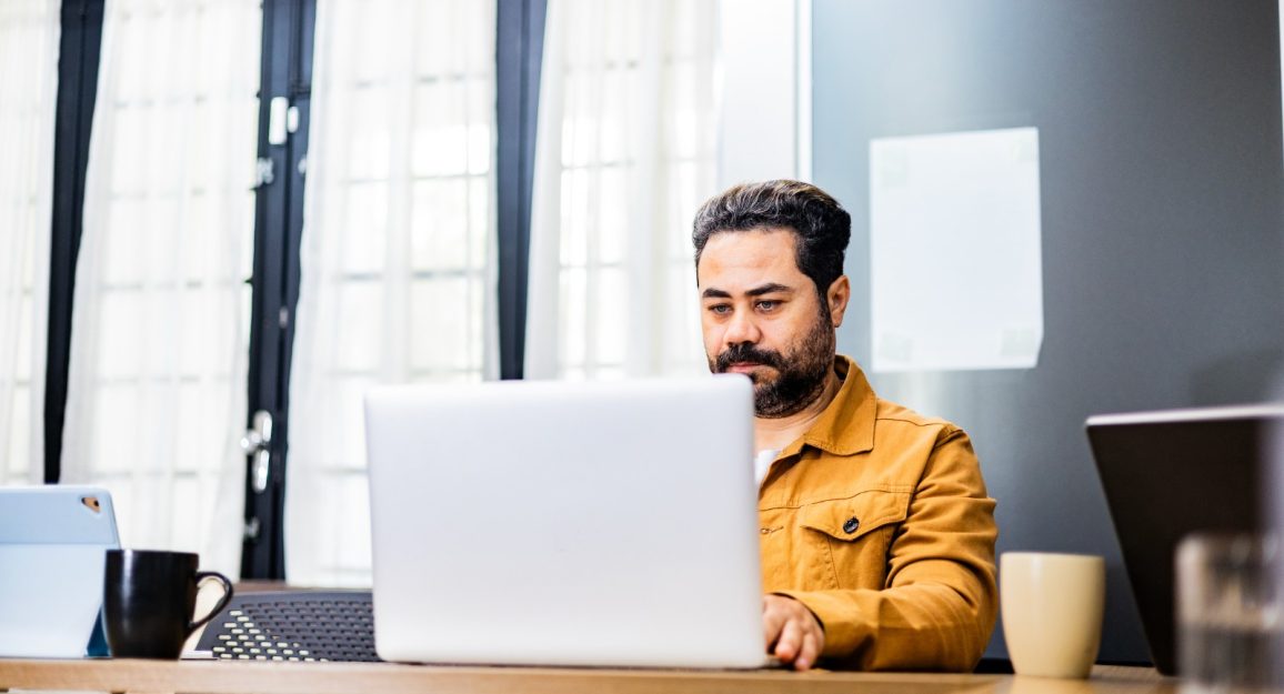 Profissional trabalhando em coworking no modelo de trabalho híbrido