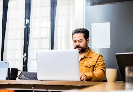 Profissional trabalhando em coworking no modelo de trabalho híbrido