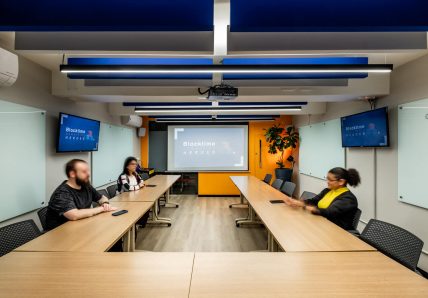 Equipe reunida em sala da Blocktime Coworking Heroes, em Pinheiros, São Paulo, para encontro presencial no modelo de trabalho híbrido.